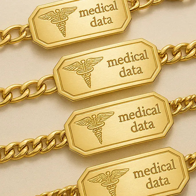 Four gold medical ID bracelets with engraved caduceus symbols and "medical data" text, displayed on a soft beige background