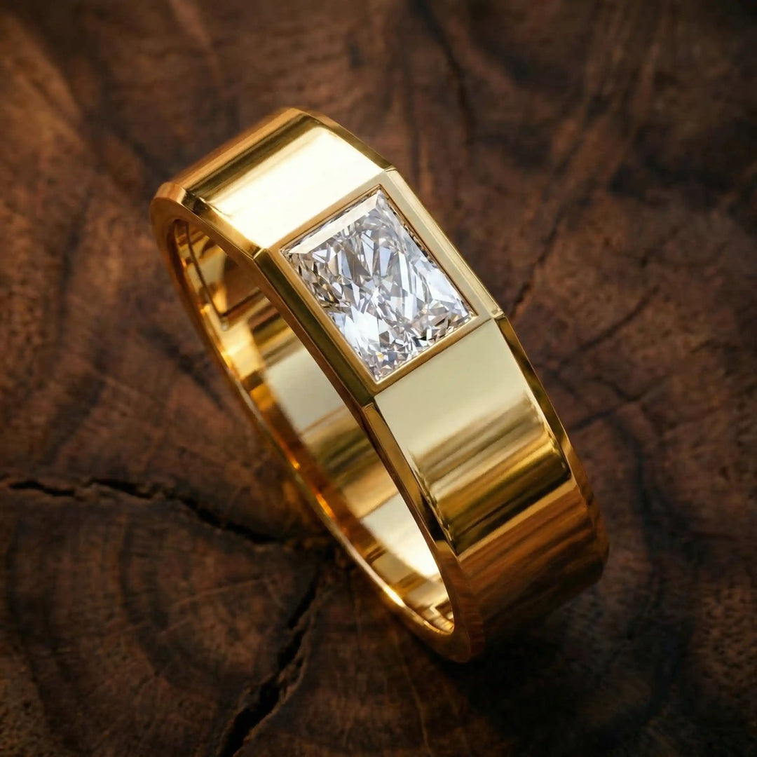Emerald cut lab-grown diamond bezel ring displayed on wood surface.