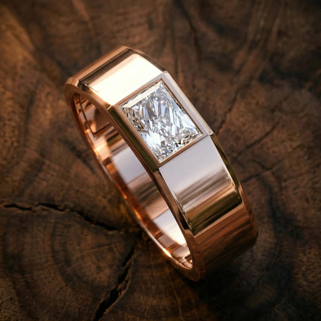 Emerald cut lab-grown diamond bezel ring displayed on wood surface.