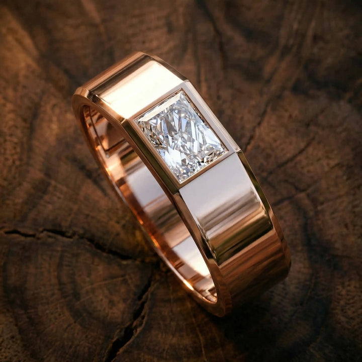 Emerald cut lab-grown diamond bezel ring displayed on wood surface.