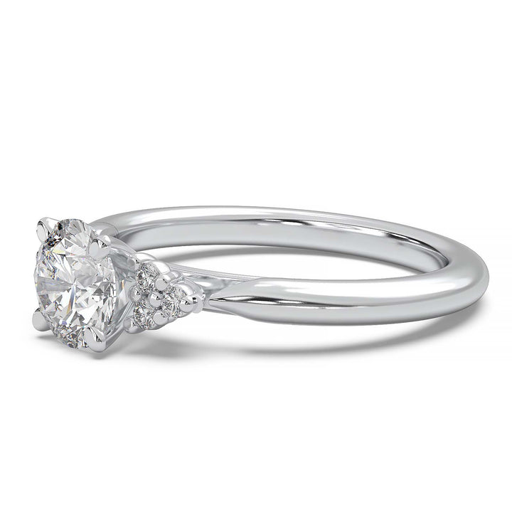 Round lab-grown diamond cluster engagement ring with a low-profile setting and accent diamonds.