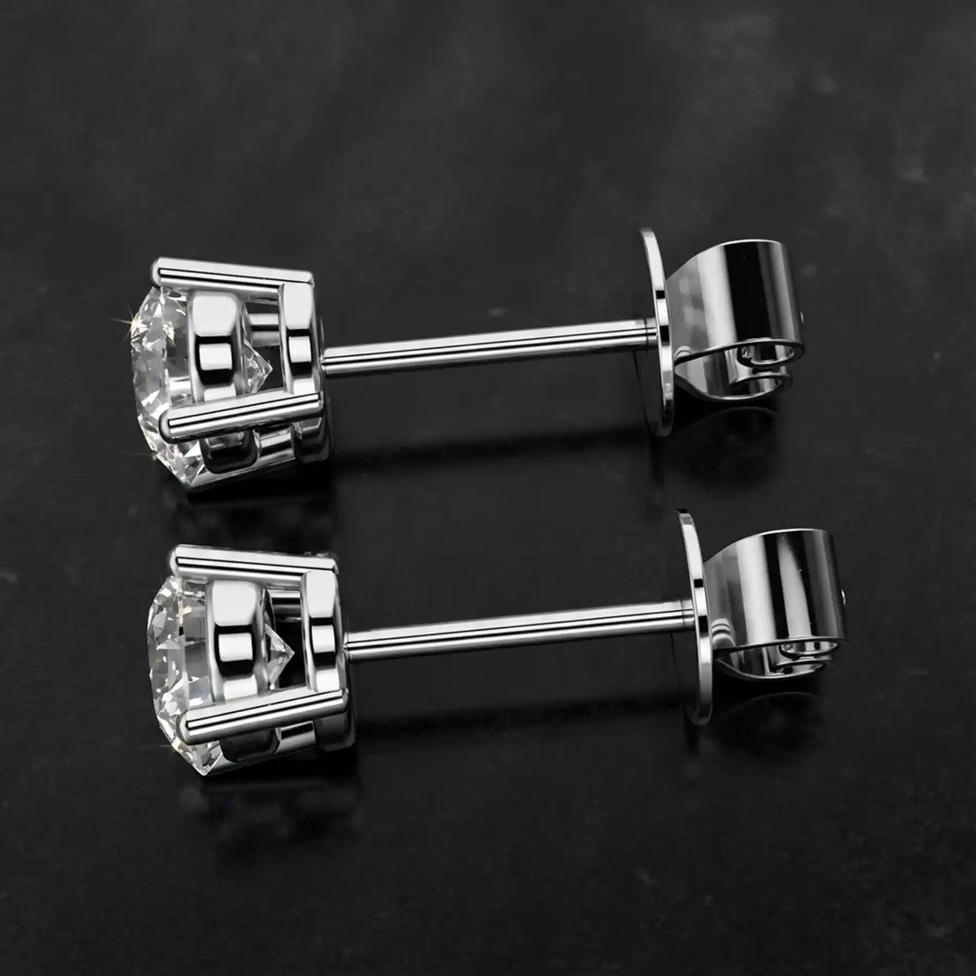 Round lab-grown diamond four-prong basket stud earrings displayed on black surface.