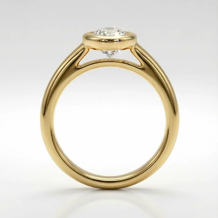 Marquise lab-grown diamond bezel engagement ring displayed on a soft surface.

