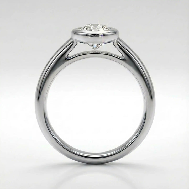 Marquise lab-grown diamond bezel engagement ring displayed on a soft surface.
