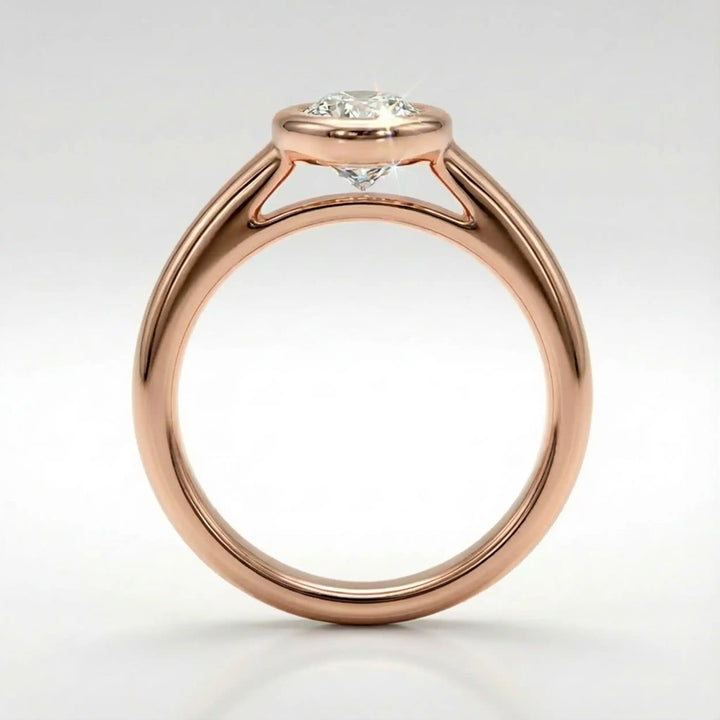 Marquise lab-grown diamond bezel engagement ring displayed on a soft surface.
