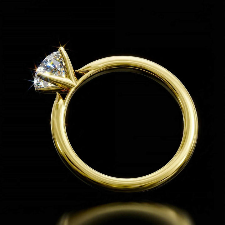 Round diamond cathedral solitaire engagement ring shown on reflective surface.