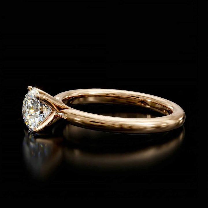 Round diamond cathedral solitaire engagement ring shown on reflective surface.
