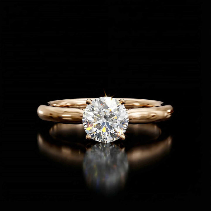 Round diamond cathedral solitaire engagement ring shown on reflective surface.
