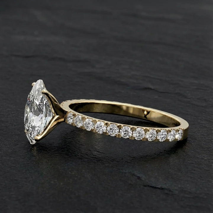 Oval lab diamond pavé engagement ring displayed on dark stone background.