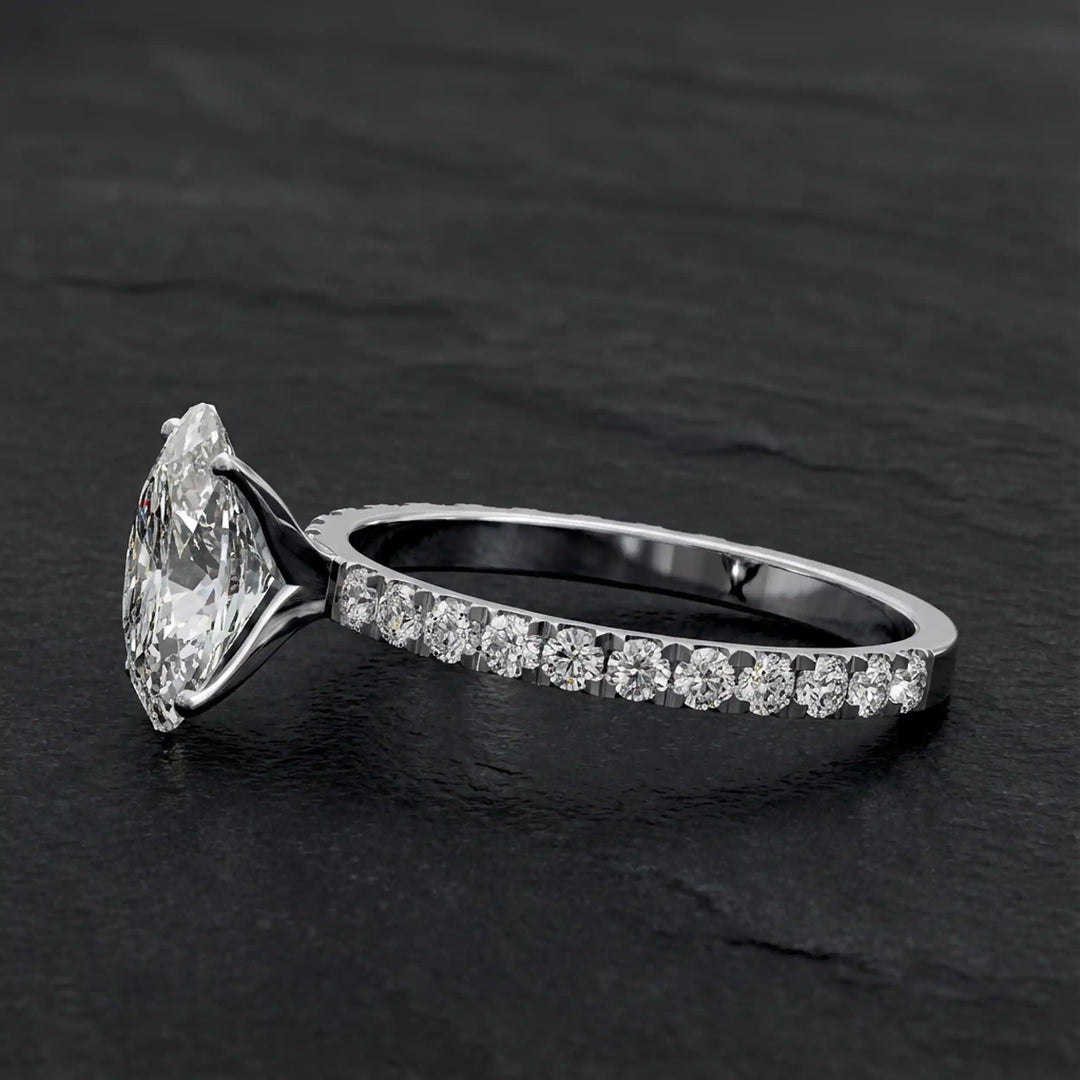 Oval lab diamond pavé engagement ring displayed on dark stone background.