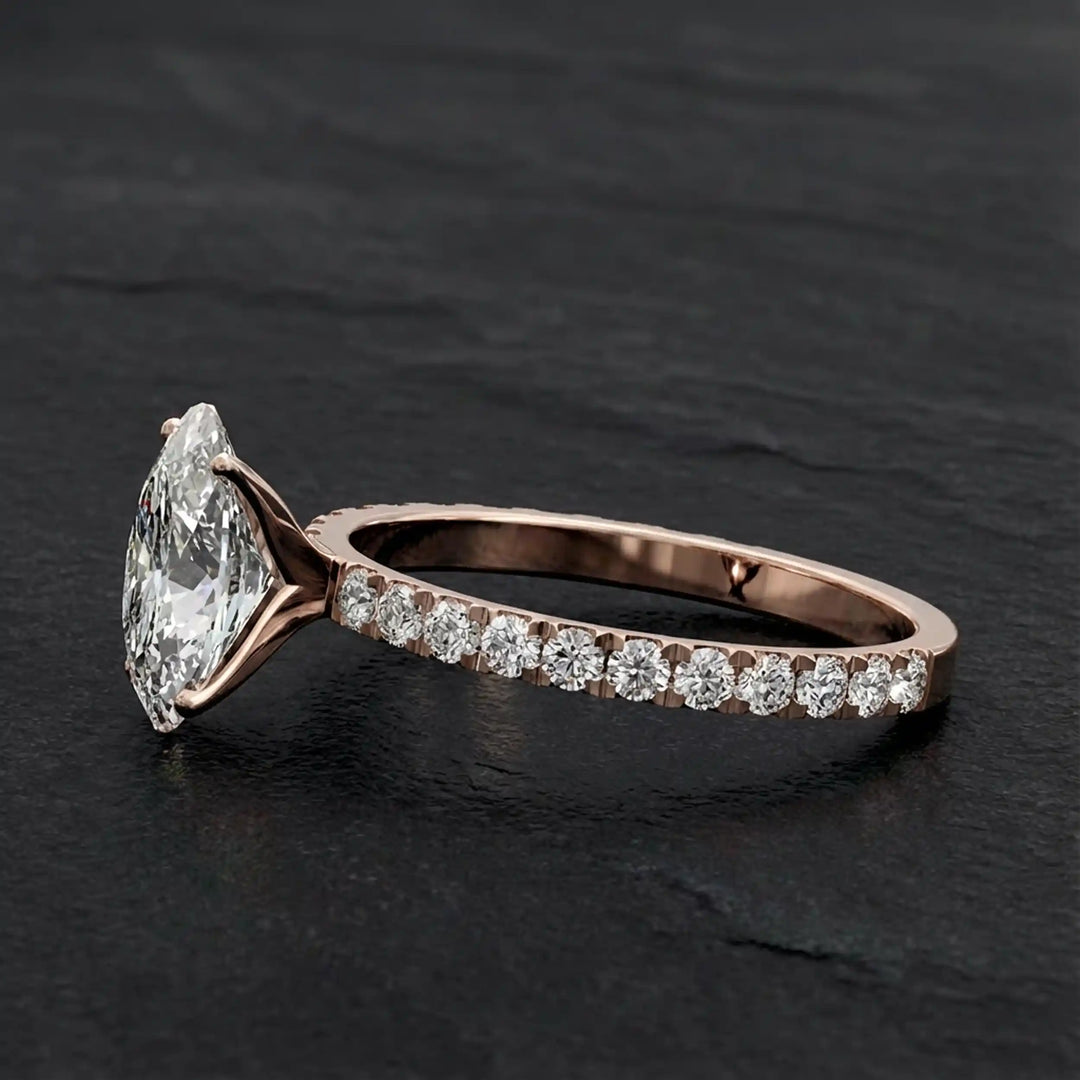 Oval lab diamond pavé engagement ring displayed on dark stone background.