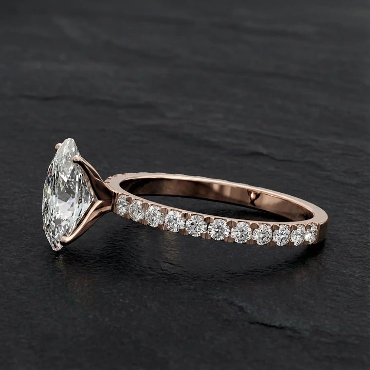 Oval lab diamond pavé engagement ring displayed on dark stone background.