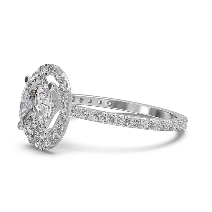 Oval diamond halo engagement ring with pavé diamond band and custom prong setting.