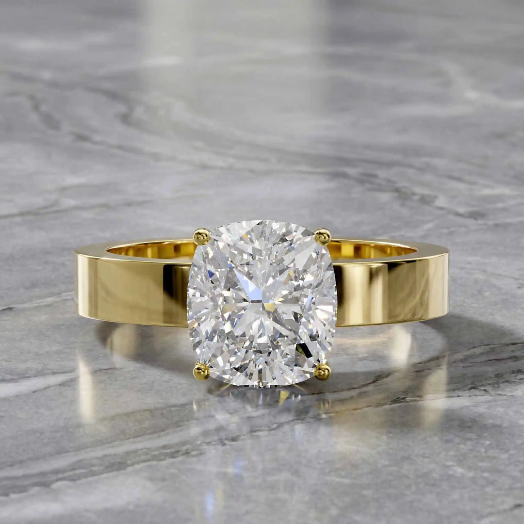 Elongated cushion lab grown diamond solitaire ring on wide flat band shown on display.