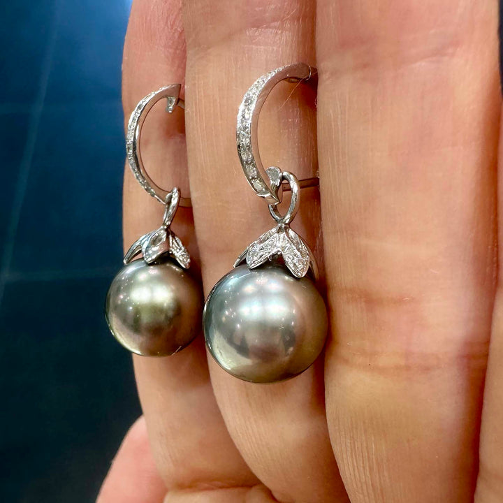 Light gray Tahitian pearl earrings with green overtone, 10.5mm round pearls set in 14K white gold with small diamonds.