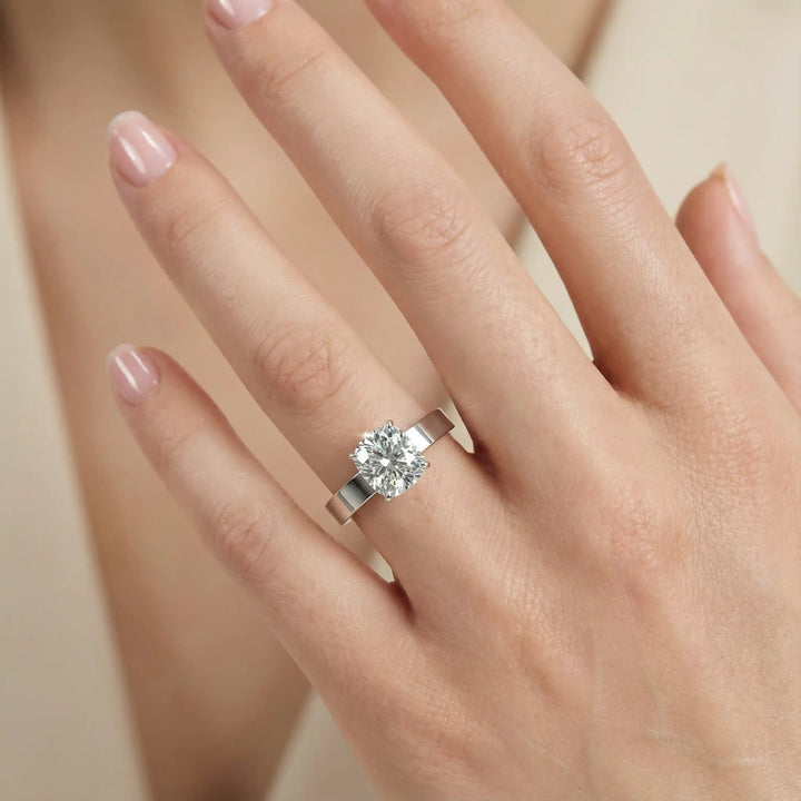Elongated cushion lab grown diamond solitaire ring on wide flat band shown on hand.