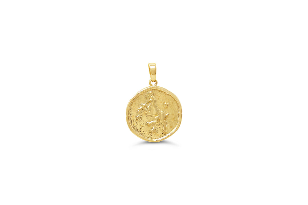 10K yellow gold Aries zodiac pendant: a round medallion with a leaping ram raised in polished gold and small stars on a textured background