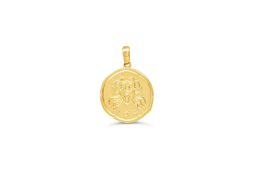 10K yellow gold Cancer zodiac pendant: a round medallion with a crab raised in polished gold and small stars on a textured background