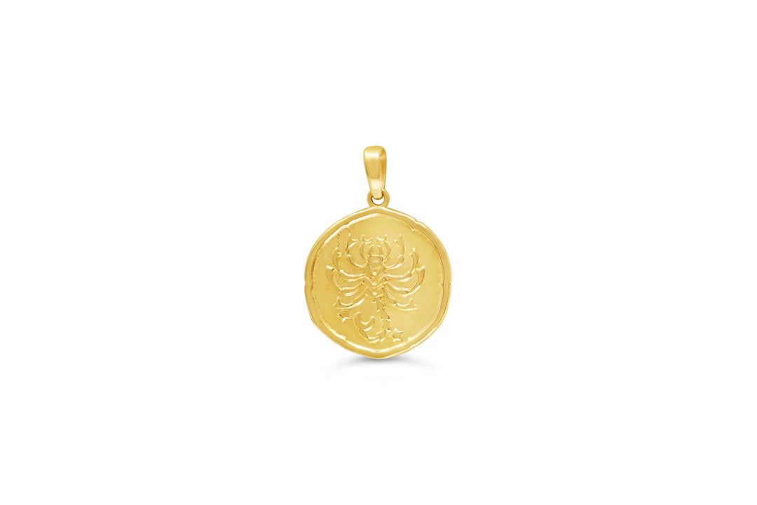 10K yellow gold Scorpio zodiac pendant: a round medallion with a scorpion raised in polished gold and small stars on a textured background