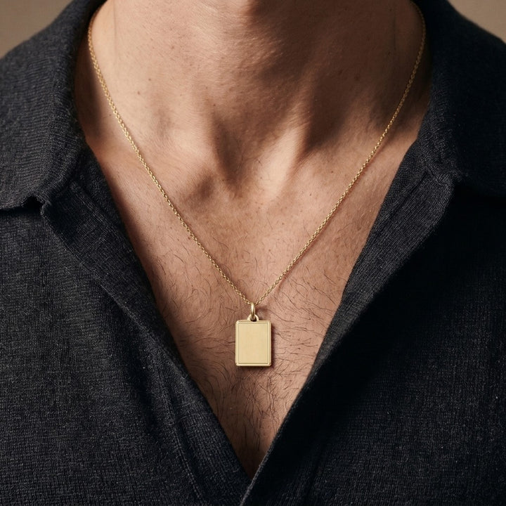 18K yellow gold satin finish rectangular tag pendant with polished line border, 19.4 x 14.9 mm, worn by a man on a 22 inch chain