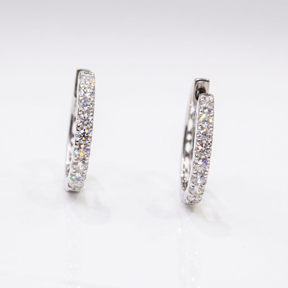 Side studio view of RUDIX 18k white gold natural diamond huggie hoop earrings — diamond fronts and polished white gold sides