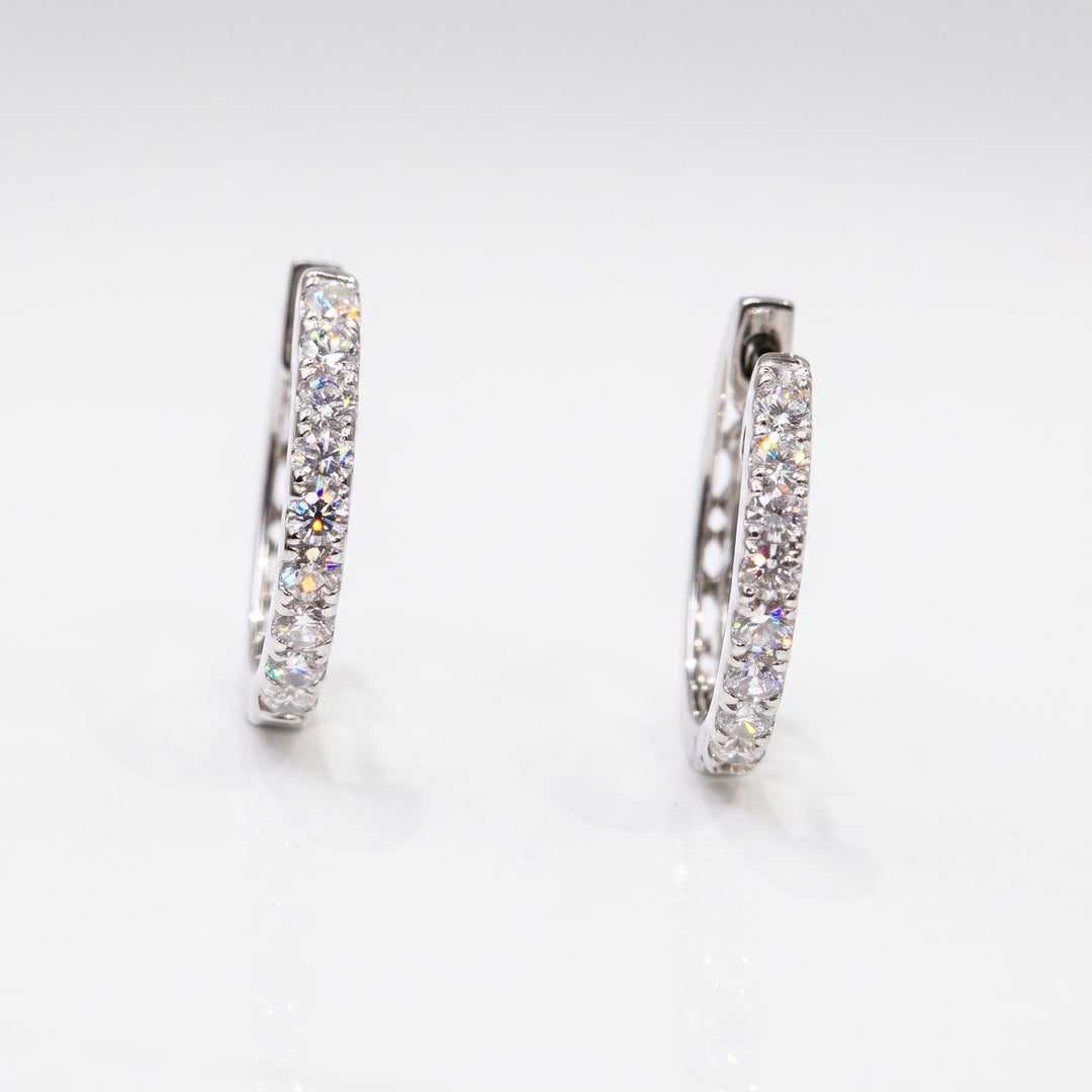 Side studio view of RUDIX 18k white gold natural diamond huggie hoop earrings — diamond fronts and polished white gold sides