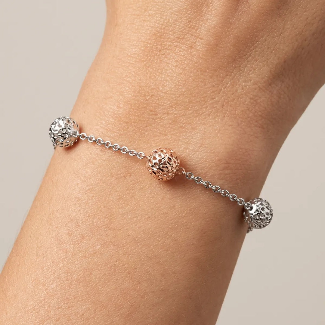Rose and white gold ball link bracelet worn on wrist showing scale and fit