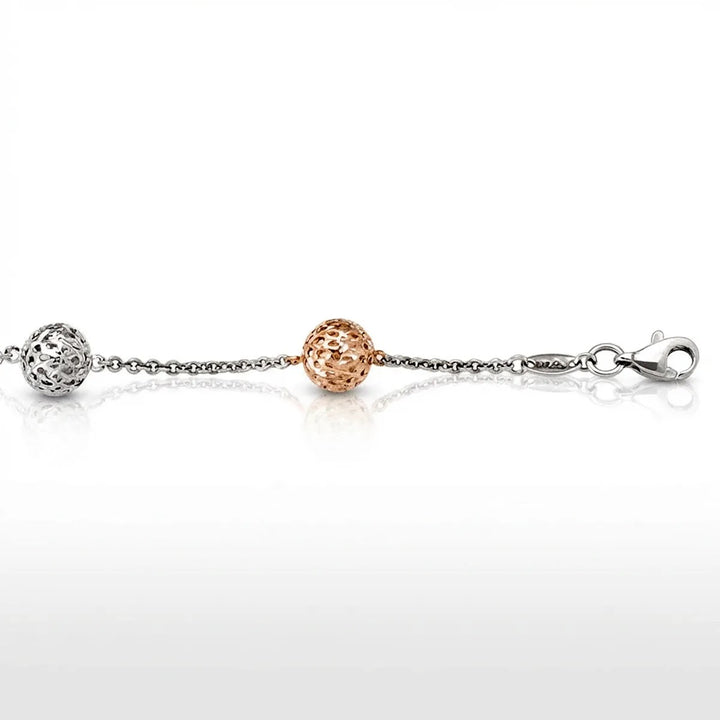 Two-tone white and rose gold fancy ball link bracelet with intricate openwork design