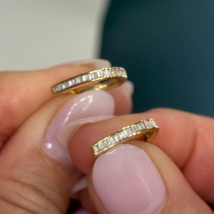 Close view of the baguette channel on 14k yellow gold huggie earrings