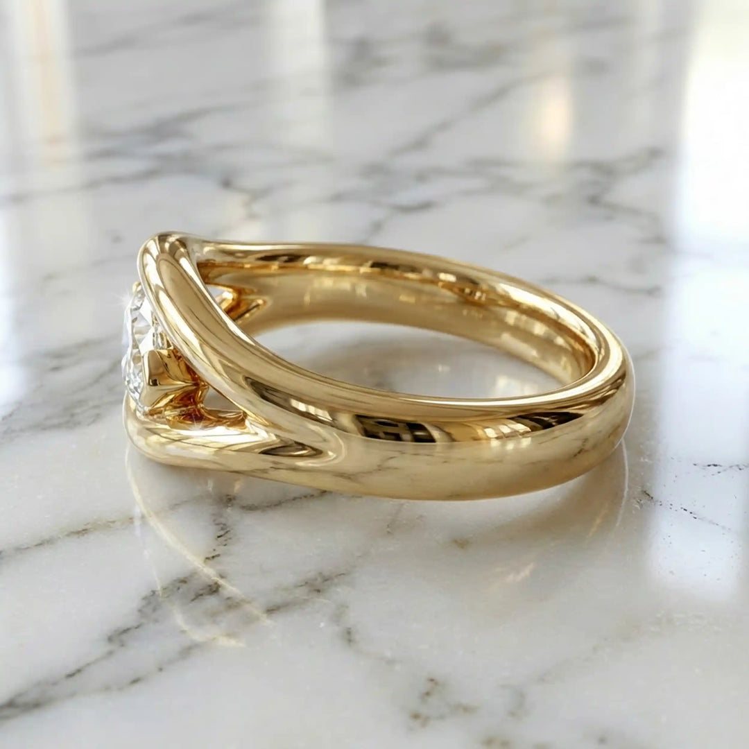 Marquise lab-grown diamond solitaire split shank engagement ring displayed on stone surface.
