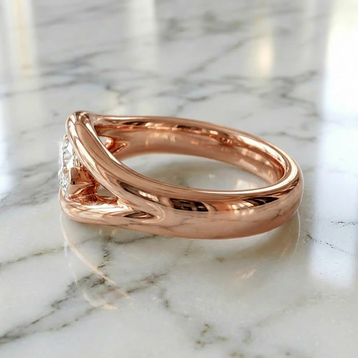 Marquise lab-grown diamond solitaire split shank engagement ring displayed on stone surface.
