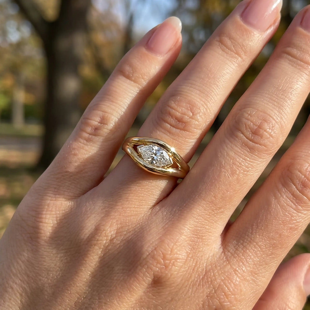 Marquise lab-grown diamond solitaire split shank engagement ring displayed on hand.
