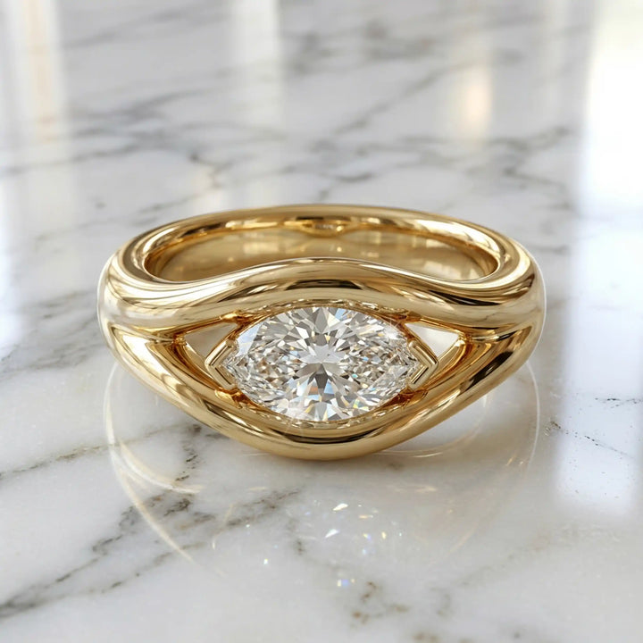 Marquise lab-grown diamond solitaire split shank engagement ring displayed on stone surface.
