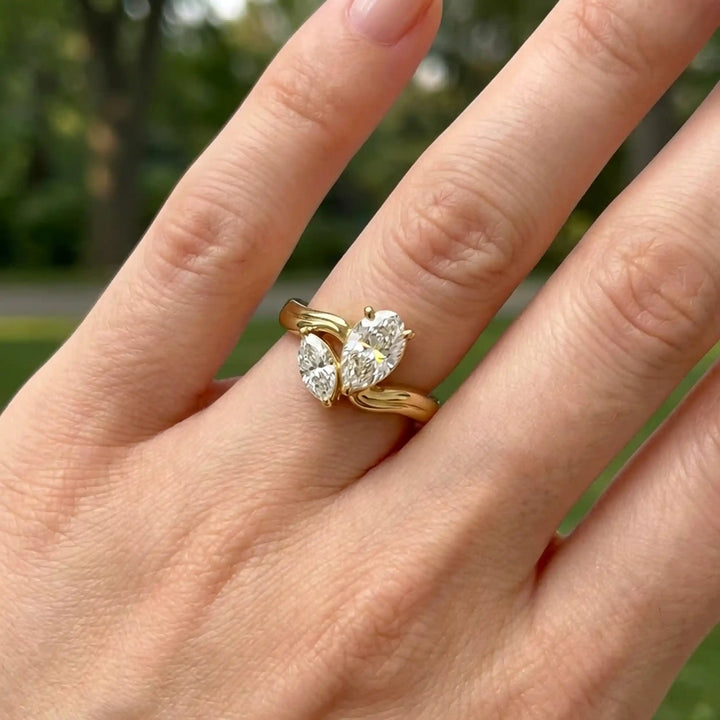 Lab-grown pear and marquise diamond toi et moi solitaire engagement ring displayed on hand.
