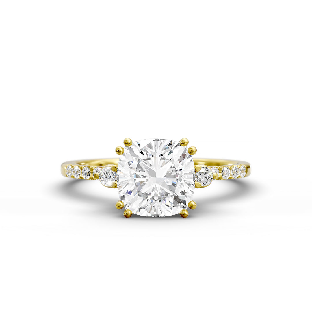 Cushion diamond three-stone engagement ring with pavé band shown in studio lighting.