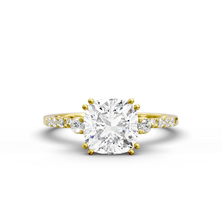 Cushion diamond three-stone engagement ring with pavé band shown in studio lighting.