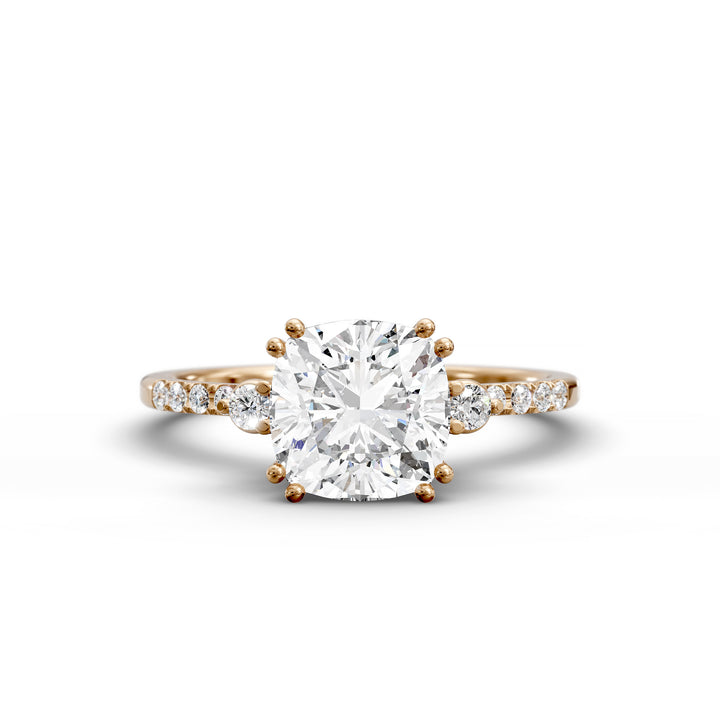 Cushion diamond three-stone engagement ring with pavé band shown in studio lighting.