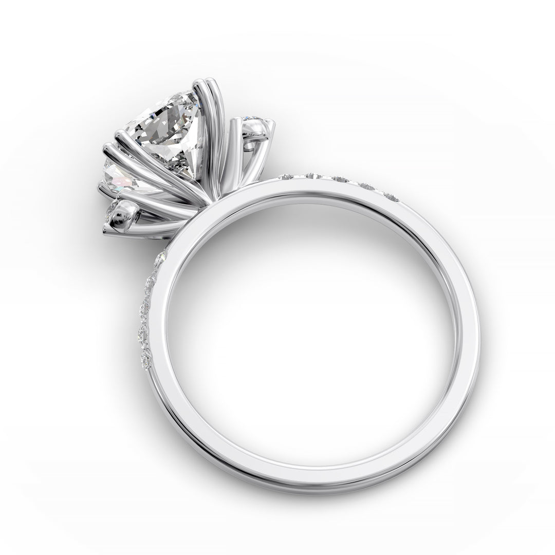 Cushion diamond three-stone engagement ring with pavé band shown in studio lighting.