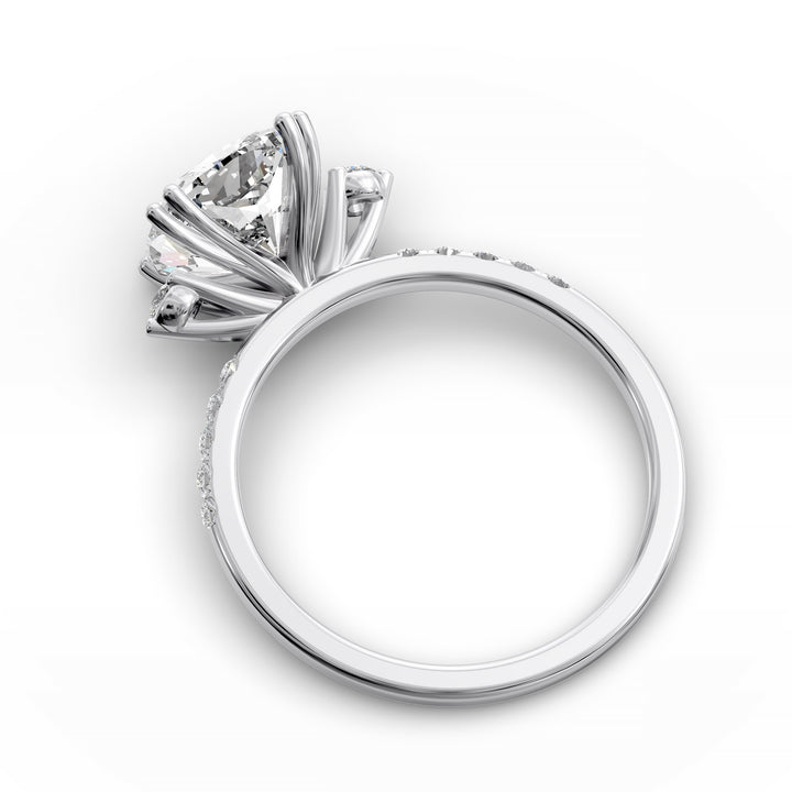 Cushion diamond three-stone engagement ring with pavé band shown in studio lighting.