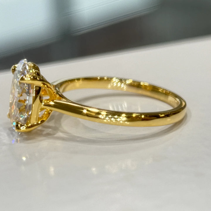 Profile view of the 14k yellow gold band, open gallery and four-claw head on the 1.92 ct oval lab-grown diamond solitaire engagement ring