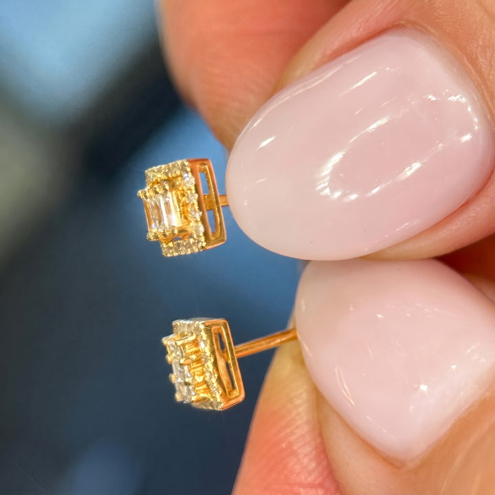 14k yellow gold natural diamond studs in hand, side view with posts