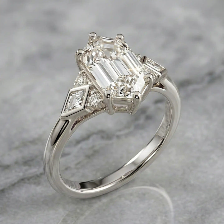 Elongated hexagonal lab-grown diamond engagement ring with side stones on a polished surface.
