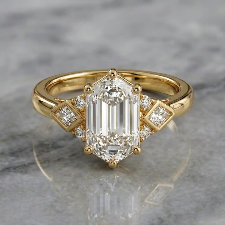 Elongated hexagonal lab-grown diamond engagement ring with side stones on a polished surface.
