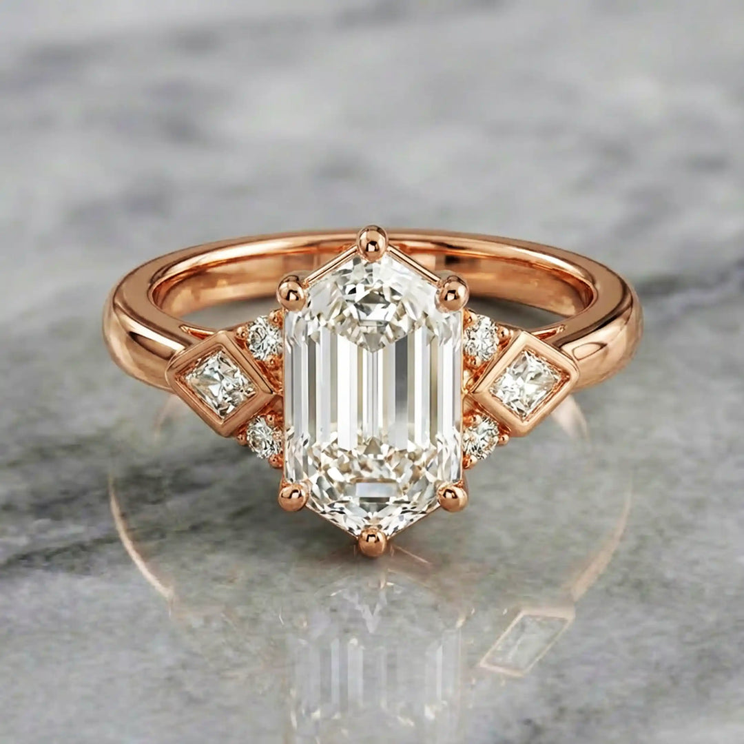 Elongated hexagonal lab-grown diamond engagement ring with side stones on a polished surface.
