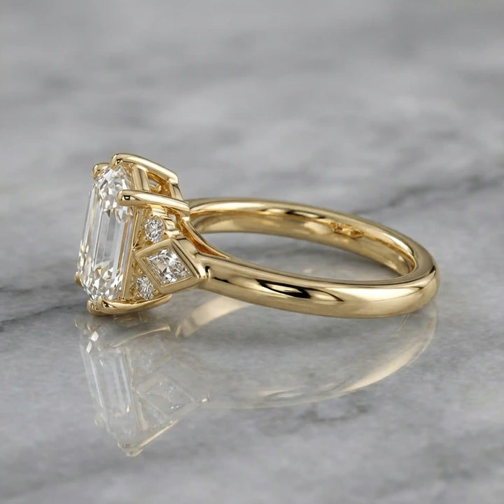Elongated hexagonal lab-grown diamond engagement ring with side stones on a polished surface.
