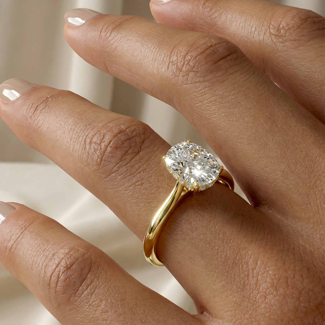 Elongated cushion diamond hidden halo cathedral engagement ring shown on display.
