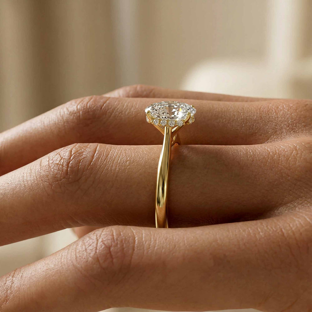 Elongated cushion diamond hidden halo cathedral engagement ring shown on display.
