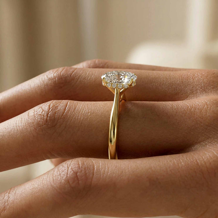 Elongated cushion diamond hidden halo cathedral engagement ring shown on display.
