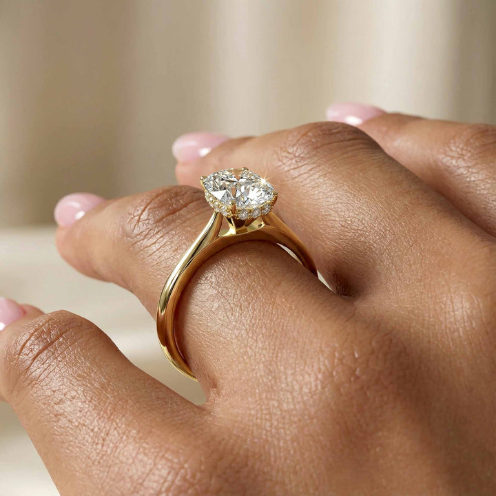 Elongated cushion diamond hidden halo cathedral engagement ring shown on display.
