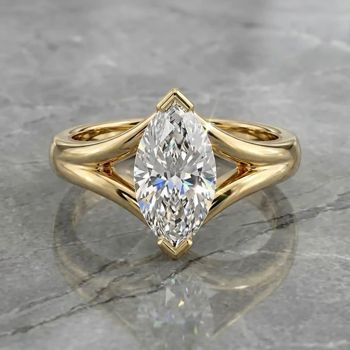 2 carat lab-grown marquise diamond split shank solitaire engagement ring displayed on stone surface.